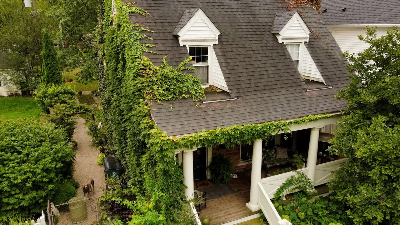 Close aerial drone view of a residential roof with dormers
